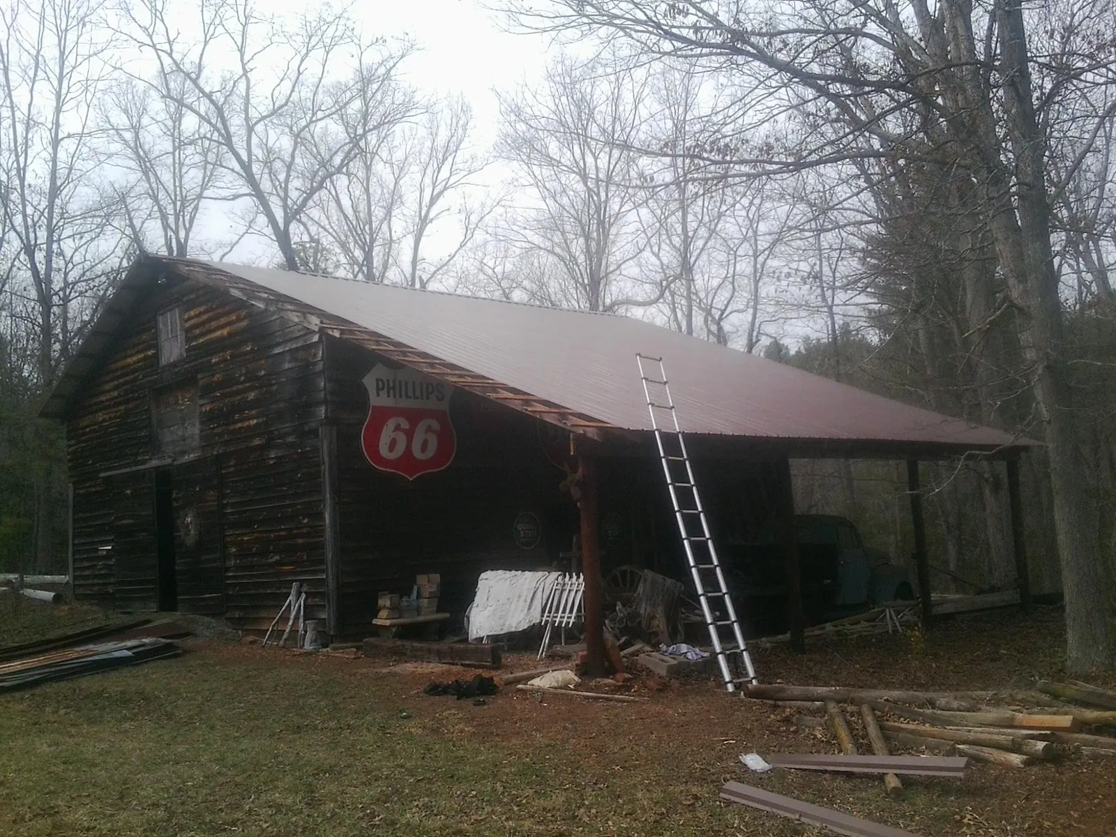 New metal roof on an open sided timber barn with a vintage sign in Lumberton