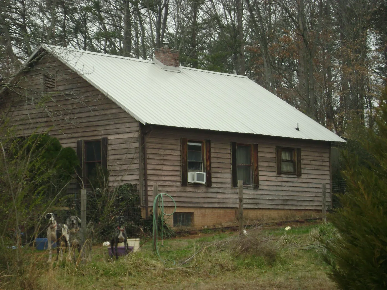 White metal roof on an old wood sided farmhouse, from a Metal Roof Installation job in Lumberton